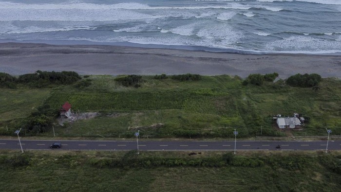Foto udara kendaraan melintas di Jalur Pantai Selatan (Pansela) Kabupaten Garut, Jawa Barat, Rabu (27/4/2022). Kementerian Pekerjaan Umum dan Perumahan Rakyat (PUPR) merekomendasikan pemudik untuk menggunakan jalur Pansela yang terbentang dari Bayah Banten, melalui Kebumen, Cilacap, Wonosari sampai ke Pacitan, Jawa Timur dengan jarak tempuh 1.405 kilometer. ANTARA FOTO/Adeng Bustomi/YU