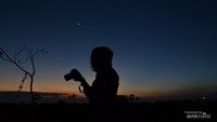 Seorang fotografer mengabadikan momen sambil menunggu waktu berbuka puasa.
