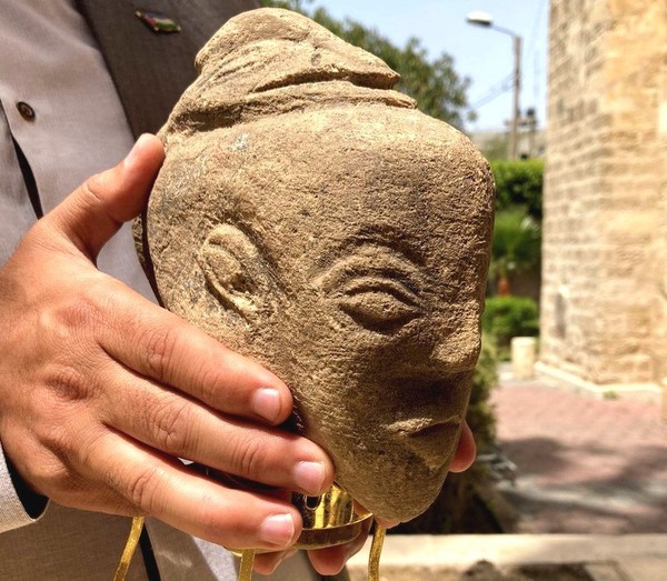 Kepala patung ini berukuran sekitar 22 cm yang menunjukan wajah demi dengan mahkota ular di atasnya. Patung ini pun diukir di batu kapur. (dok BBC)