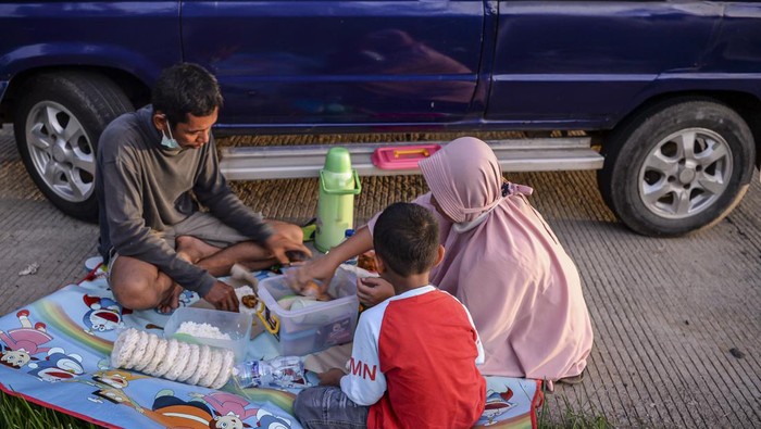 Sejumlah pemudik menyantap hidangan buka puasa bersama di pinggir ruas jalan Tol Cikopo-Palimanan, Subang, Jawa Barat, Kamis (28/4/2022). ANTARA FOTO/M Risyal Hidayat/tom.