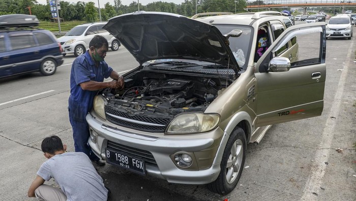 Seorang teknisi memperbaiki mobil milik pemudik yang mengalami kerusakan di pinggir ruas Jalan Tol Cikopo-Palimanan, Subang, Jawa Barat, Kamis (28/4/2022). ANTARA FOTO/M Risyal Hidayat/tom.