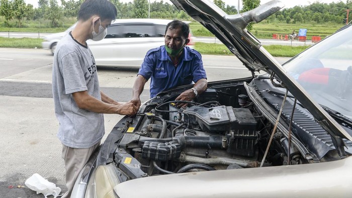 Seorang teknisi memperbaiki mobil milik pemudik yang mengalami kerusakan di pinggir ruas Jalan Tol Cikopo-Palimanan, Subang, Jawa Barat, Kamis (28/4/2022). ANTARA FOTO/M Risyal Hidayat/tom.