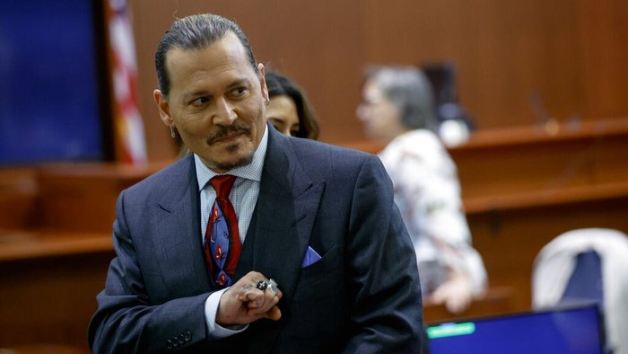 Actor Johnny Depp watches a pre-recorded deposition testimony of Christian Carino at the Fairfax County Circuit Court in Fairfax, Va., Wednesday, April 27, 2022. Depp sued his ex-wife actress Amber Heard for libel in Fairfax County Circuit Court after she wrote an op-ed piece in The Washington Post in 2018 referring to herself as a public figure representing domestic abuse. (Jonathan Ernst/Pool Photo via AP)