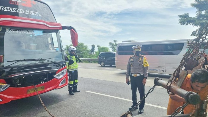 Petugas menderek bus yang mogok di Tol Jakarta-Cikampek