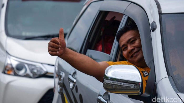 Macet menjelang GT Merak, Banten, membuat sebagian pemudik 'membunuh' waktu untuk mengusir penat. Pemudik kebanyakan keluar sejenak dari mobilnya.