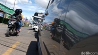 Sejumlah pemotor melintas di antara kendaraan yang terjebak macet di jalan arteri menuju Pelabuhan Merak.