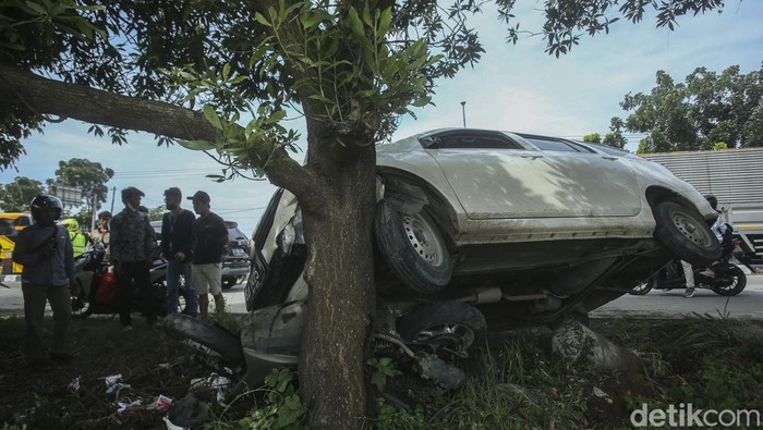 Mobil Banting Setir Hingga Tabrak Motor di Karawang Bripka Tito Rama mengamati kendaraan mobil yang terlibat laka lantas di Jalan Lingkar Tanjung pura, Karawang, Jumat (29/4/2022).