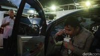 Pemudik menyantap mi dalam gelas saat berbuka puasa.