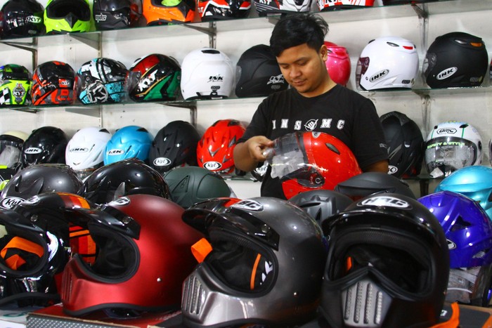 Pedagang menata helm jualannya di sentra penjualan helm di Embong Brantas, Malang, Jawa Timur, Jumat (29/4/2022). Penjual helm di kawasan tersebut mengatakan sejak pemerintah memperbolehkan mudik Lebaran penjualan helm meningkat dari 5 unit menjadi 30 unit per hari. ANTARA FOTO/Ari Bowo Sucipto/nz