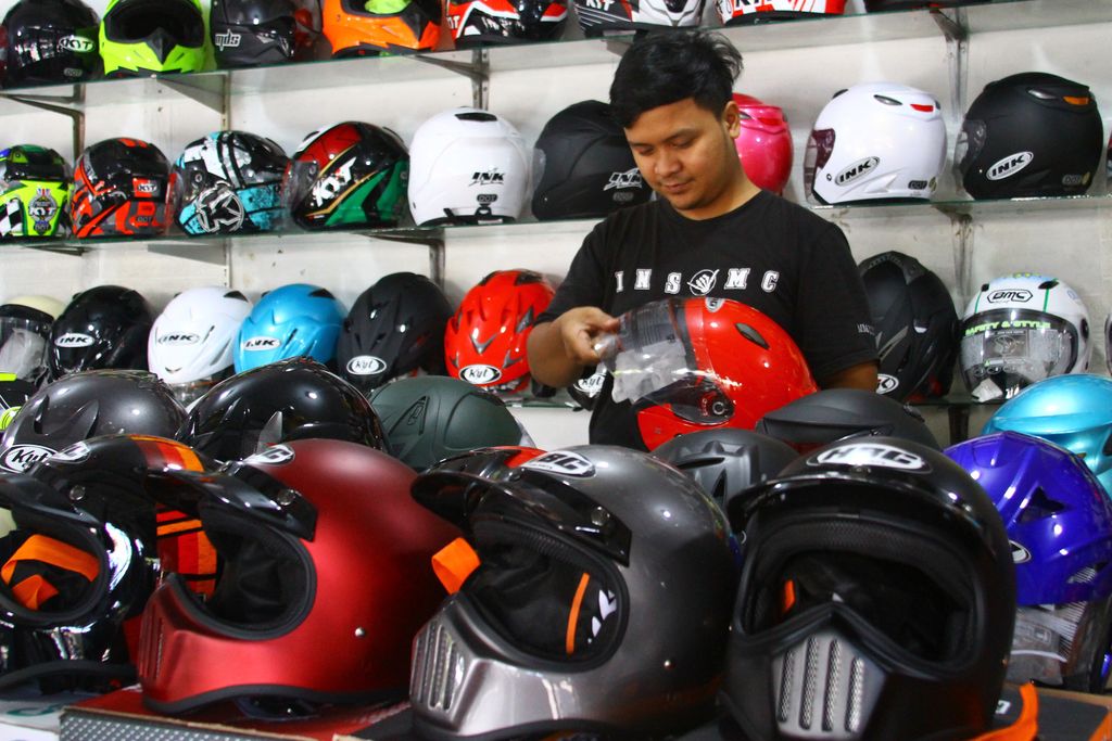 Pedagang menata helm jualannya di sentra penjualan helm di Embong Brantas, Malang, Jawa Timur, Jumat (29/4/2022). Penjual helm di kawasan tersebut mengatakan sejak pemerintah memperbolehkan mudik Lebaran penjualan helm meningkat dari 5 unit menjadi 30 unit per hari. ANTARA FOTO/Ari Bowo Sucipto/nz