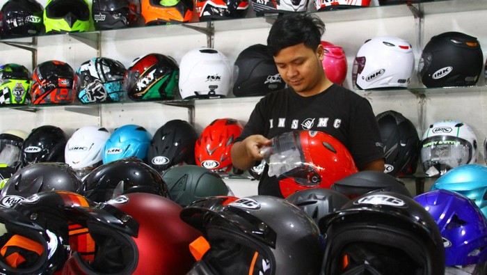 Pedagang menata helm jualannya di sentra penjualan helm di Embong Brantas, Malang, Jawa Timur, Jumat (29/4/2022). Penjual helm di kawasan tersebut mengatakan sejak pemerintah memperbolehkan mudik Lebaran penjualan helm meningkat dari 5 unit menjadi 30 unit per hari. ANTARA FOTO/Ari Bowo Sucipto/nz