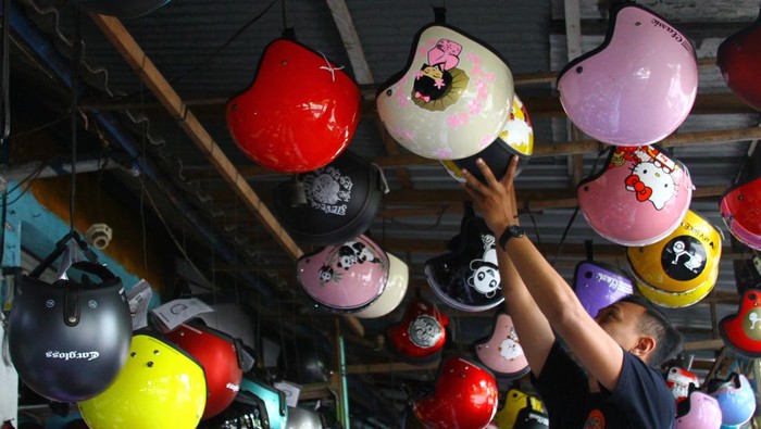 Pedagang menata helm jualannya di sentra penjualan helm di Embong Brantas, Malang, Jawa Timur, Jumat (29/4/2022). Penjual helm di kawasan tersebut mengatakan sejak pemerintah memperbolehkan mudik Lebaran penjualan helm meningkat dari 5 unit menjadi 30 unit per hari. ANTARA FOTO/Ari Bowo Sucipto/nz