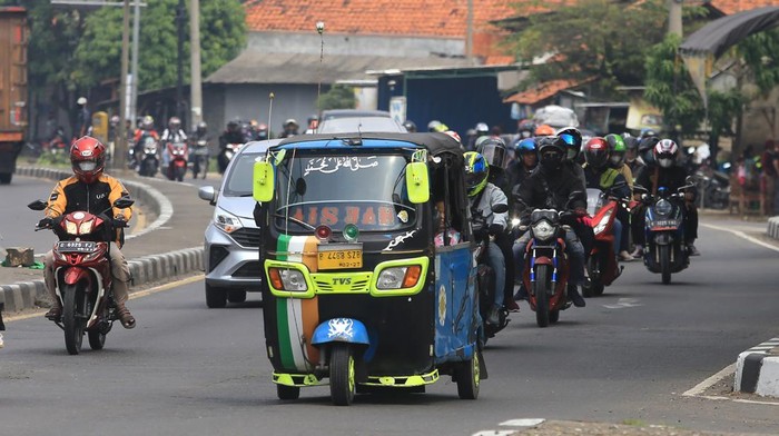 Pemudik yang menggunakan bajaj melintas jalur Pantura Simpang Lohbener, Indramayu, Jawa Barat, Jumat (29/4/2022). Pemudik menggunakan kendaraan khas ibukota untuk pulang kampung sehingga menjadi perhatian warga daerah karena keunikannya. ANTARA FOTO/Dedhez Anggara/nz.