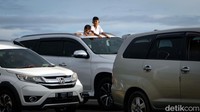 Dua orang terlihat keluar dari atap mobil yang terjebak kemacetan menuju Pelabuhan Merak.