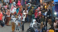Nampak manusia silver mengais rejeki dari belas kasih warga yang tengah belanja di pasar.