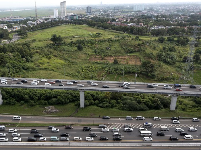 Polisi merapikan rambu kerucut pada ruas jalan tol Jakarta-Cikampek kilometer 47 di Karawang, Jawa Barat, Jumat (29/4/2022). Polri menggeser pintu masuk arus lalu lintas satu arah (one way) dari KM 47 Tol Jakarta-Cikampek ke Gerbang Tol Cikampek Utam