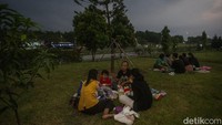 Tak hanya di dekat mobil, pemudik juga memanfaatkan taman di rest area untuk santai sejenak dan berbuka puasa.