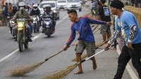 Aksi mengambil sedekah dengan sapu cukup menarik perhatian warga atau pemudik yang melintas.