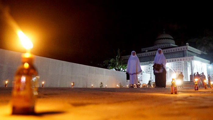 Tradisi Tumbilotohe di Gorontalo Wakil Bupati Gorontalo Hendra Hemeto menyalakan lampu minyak di alikusu (arkus) yang terbuat dari bambu dan janur kelapa tanda dimulai tradisi Tumbilotohe atau malam pasang lampu di halaman rumah dinas Bupati di Kabupaten Gorontalo, Gorontalo, Kamis (28/4/2022). Tradisi Tumbilotohe untuk menyambut Hari Raya Idul Fitri kembali digelar setelah selama dua tahun dibatasi karena pandemi COVID-19. ANTARA FOTO/Adiwinata Solihin/tom.