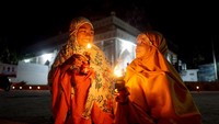 Dua bocah memegang lampu minyak dalam tradisi Tumbilotohe atau malam pasang lampu yang dinyalakan di halaman masjid, di Hutuo, Kabupaten Gorontalo, Gorontalo, Kamis (28/4/2022).