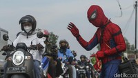 Karsim (35) menggunakan kostum Spiderman di Jalur Pantura, Sabtu (30/4/2022). Aksi tersebut dilakukan guna menghibur para pemudik.  