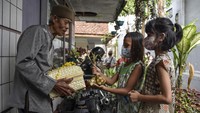 Dua orang anak dari umat kristiani memberikan paket ketupat Lebaran kapada warga umat Islam di Kampung Kerukunan, Lebak, Kabupaten Ciamis, Jawa Barat, Sabtu (30/4/2022).