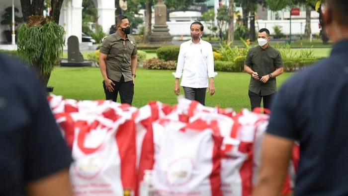 Presiden Joko Widodo membagikan paket sembako bagi masyarakat di sekitar Gedung Agung, Istana Kepresidenan Yogyakarta, Sabtu (30/4/2022).