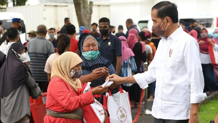 Presiden Joko Widodo membagikan paket sembako bagi masyarakat di sekitar Gedung Agung, Istana Kepresidenan Yogyakarta, Sabtu (30/4/2022).