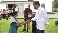 Tampak Presiden Jokowi memberikan hadiah labaran untuk warga.  