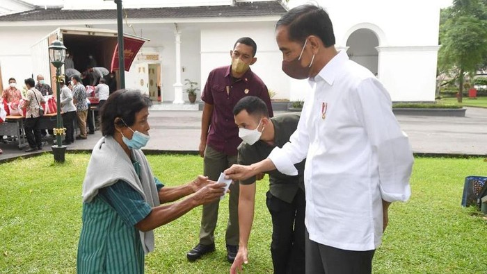 Presiden Joko Widodo membagikan paket sembako bagi masyarakat di sekitar Gedung Agung, Istana Kepresidenan Yogyakarta, Sabtu (30/4/2022).
