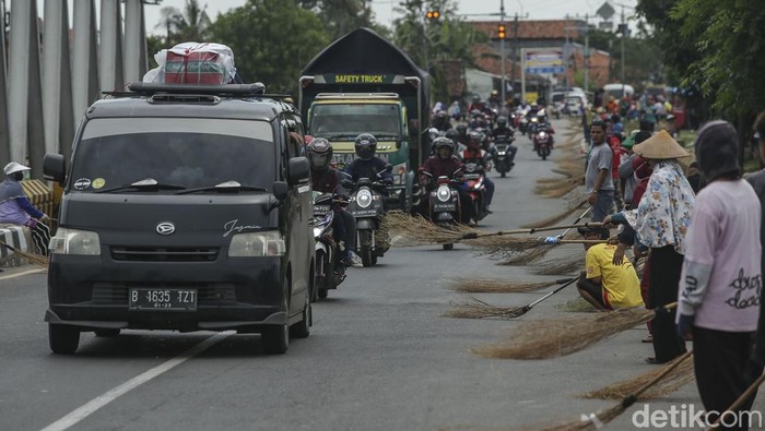 Gerombolan orang berjejer di jembatan Sewo, Indramayu, Jawa barat, Senin (14/12/2020). Momen mudik lebaran merupakan momentum bagi warga sekitar kali untuk menyapu koin-koin yang dilempar oleh pemudik yang melintas.