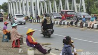 Bukan sapu lidi, warga yang berjejer memegang sapu dari kayu gemuning.  