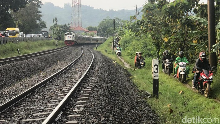 Sejumlah pemudik menggunakan roda dua menggunakan jalan tanah di sisi rel kereta api, di daerah Prupuk, Jawa Tengah, Sabtu (30/4/2022).