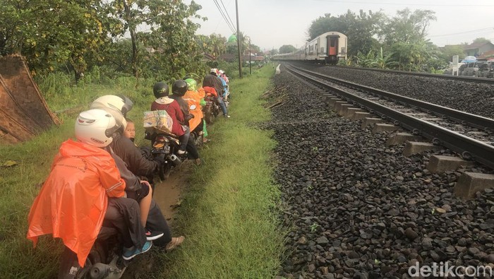 Pejuang Mudik Motor, Menerobos Jalan Tanah di Pinggir Rel Sejumlah pemudik menggunakan roda dua menggunakan jalan tanah di sisi rel kereta api, di daerah Prupuk, Jawa Tengah, Sabtu (30/4/2022).