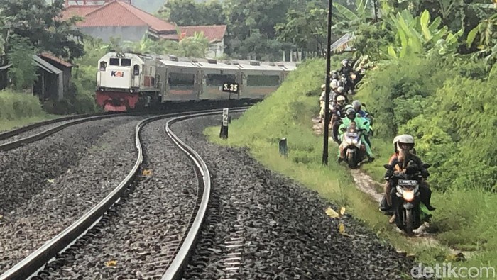 Sejumlah pemudik menggunakan roda dua menggunakan jalan tanah di sisi rel kereta api, di daerah Prupuk, Jawa Tengah, Sabtu (30/4/2022).
