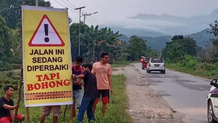 Warga Burau saat memasang spanduk protes Jalan Trans Sulawesi di wilayah mereka rusak (Dok. Istimewa)