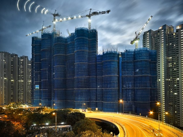 Seorang fotografer memotret fenomena bangunan kepompong. Traveler bisa melihat hasil memukau dengan objek yang berasal dari Hong Kong.