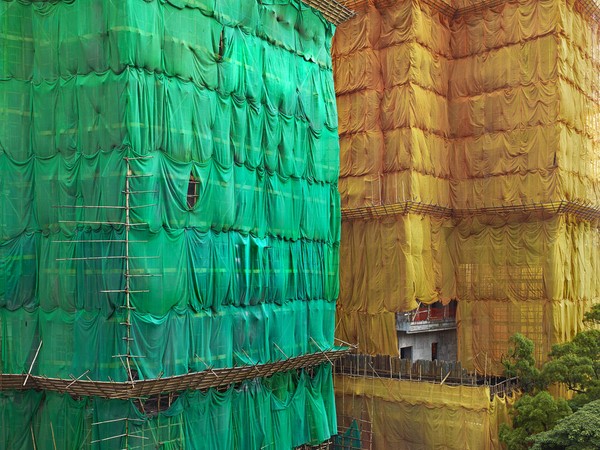 Pekerja juga terus menggunakan susunan bambu, yang berfungsi sebagai bingkai untuk pembungkus lembaran warna-warni itu. Pekerja juga terus menggunakan susunan bambu, yang berfungsi sebagai bingkai untuk pembungkus lembaran warna-warni itu.