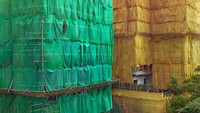 Pekerja juga terus menggunakan susunan bambu, yang berfungsi sebagai bingkai untuk pembungkus lembaran warna-warni itu.