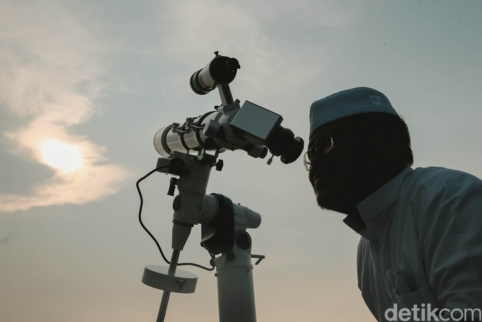 Petugas Masjid Al-Musyariin mengamati posisi hilal menggunakan teropong saat Rukyatul Hilal di Jakarta Barat, Minggu (1/5/2022). Pemantauan hilal yang dilakukan menggunakan teropong tersebut memastikan Idul Fitri 1443 H jatuh pada 2 Mei 2022.