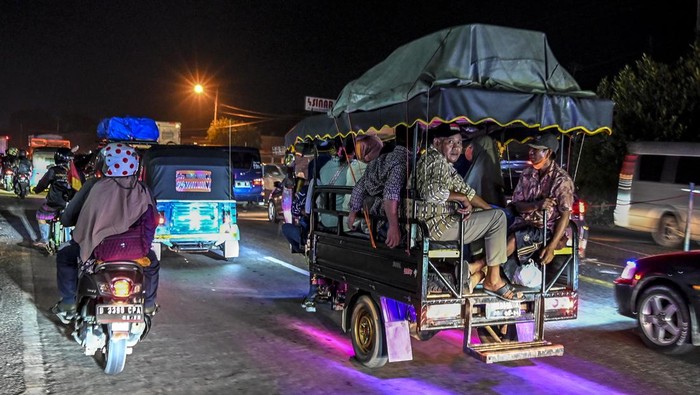 Mereka yang Mudik dengan Kendaraan Bak Terbuka Pemudik menggunakan angkutan bak terbuka melintas di Simpang Jomin, Karawang, Jawa Barat, Sabtu (30/4/2022). Meskipun ada larangan dari pihak kepolisian menggunakaan kendaraan bak terbuka untuk mudik, namun masih banyak pemudik yang menggunakan kendaraan tersebut. ANTARA FOTO/Muhammad Adimaja/pras.