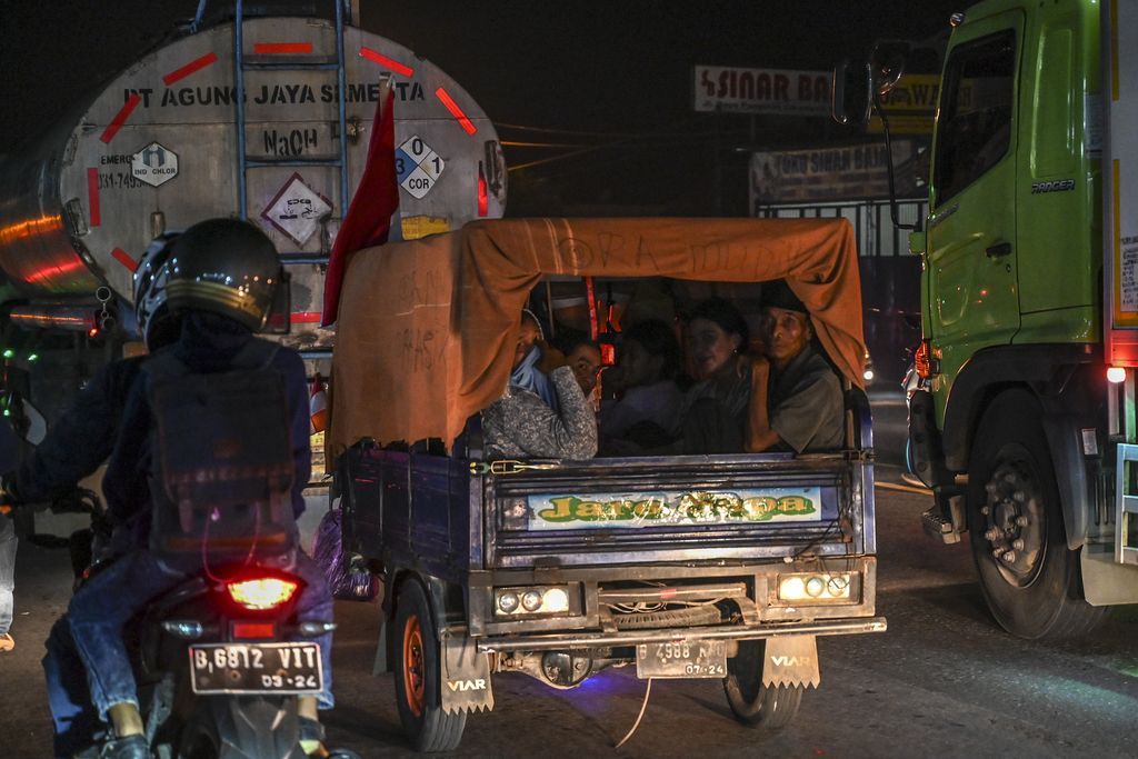 Pemudik menggunakan angkutan bak terbuka melintas di Simpang Jomin, Karawang, Jawa Barat, Sabtu (30/4/2022). Meskipun ada larangan dari pihak kepolisian menggunakaan kendaraan bak terbuka untuk mudik, namun masih banyak pemudik yang menggunakan kendaraan tersebut.  ANTARA FOTO/Muhammad Adimaja/pras.