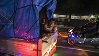 Pemudik menggunakan angkutan bak terbuka melintas di Simpang Jomin, Karawang, Jawa Barat, Sabtu (30/4/2022).