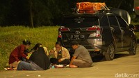 Pemudik yang tidak sempat berhenti di dalam rest area pun menghentikan kendaraannya di pinggir tol, untuk menyantap menu berbuka puasa.