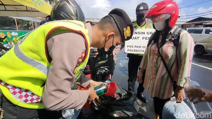 Polisi membagikan BBM pertalite dan pertamax gratis di Medaeng, Sidoarjo.