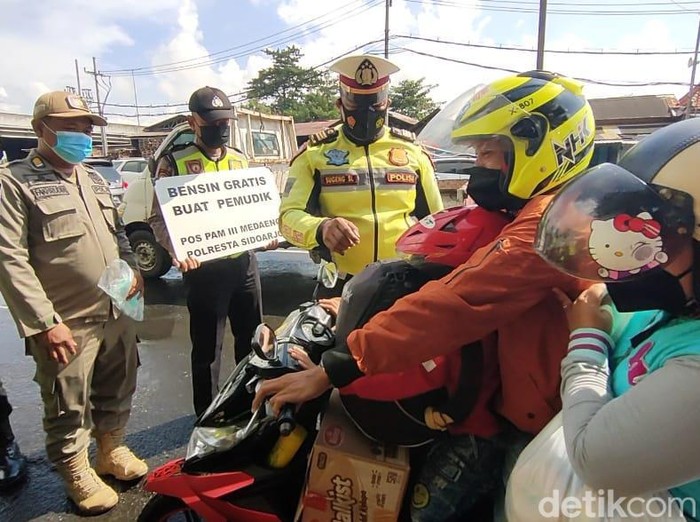Polisi membagikan BBM pertalite dan pertamax gratis di Medaeng, Sidoarjo.