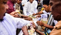 Warga umat Islam melakukan tradisi uang selawat atau sedekah wadah kain sebelum melaksanakan salat Id 1 Syawal 1443 Hijriah di Masjid Hasan Sulaiman Negeri Hila, Kabupaten Maluku Tengah, Maluku, Minggu (1/5/2022).