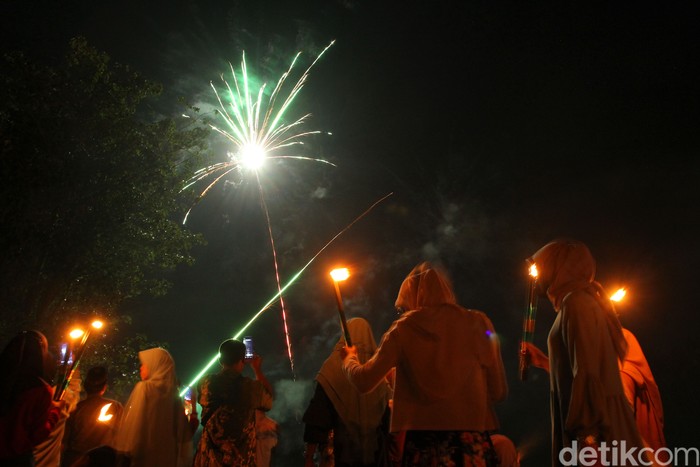 Ratusan jamaah Masjid At-Taufiq melaksanakan takbir keliling kampung menggunakan obor di dusun Ngaran, Margokaton, Seyegan, Sleman, Yogyakarta, Minggu (1/5/2022). Sebanyak 400an obor dinyalakan memeriahkan takbir keliling menyambur hari Raya Idul Fitri 1443 H.