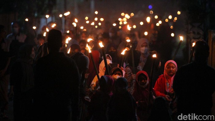 Ratusan jamaah Masjid At-Taufiq melaksanakan takbir keliling kampung menggunakan obor di dusun Ngaran, Margokaton, Seyegan, Sleman, Yogyakarta, Minggu (1/5/2022). Sebanyak 400an obor dinyalakan memeriahkan takbir keliling menyambur hari Raya Idul Fitri 1443 H.