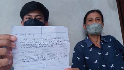 Ketut Rian Saputra (kiri) menunjukkan surat wasiat yang ditulis kakaknya, Komang Adi sebelum meninggal, Sabtu (30/4/2022).